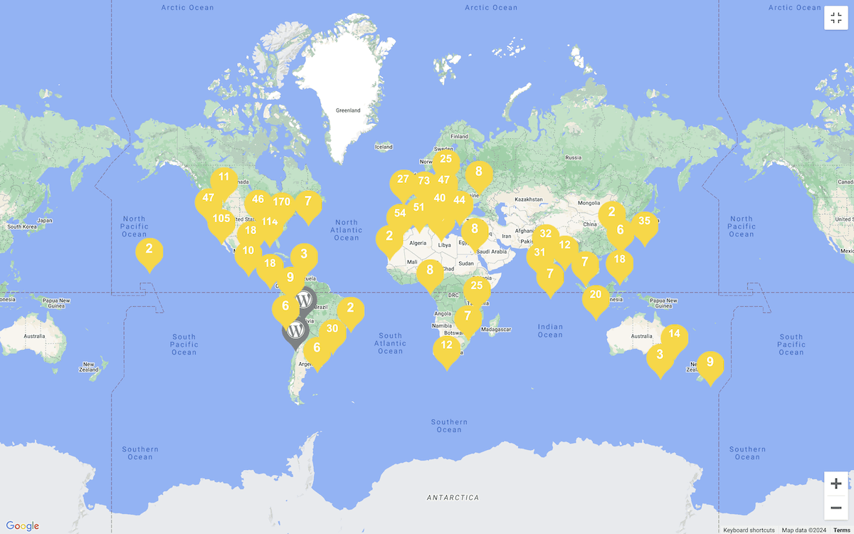 Een wereldkaart met gele markeringen met nummers, die de locaties van WordCamps in verschillende landen en continenten aangeven. De kaart toont een concentratie van markeringen in Noord-Amerika, Europa en delen van Azië.