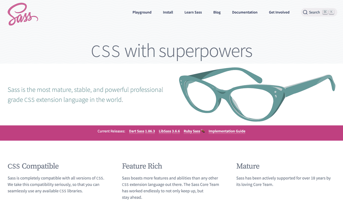 Página de inicio del sitio web del lenguaje de programación Sass, con el logotipo de Sass en rosa, un menú de navegación y el eslogan «CSS con superpoderes». A continuación, se muestra un texto descriptivo de Sass. El diseño incluye una ilustración de unas gafas de ojo de gato de color verde azulado y secciones que destacan la funcionalidad y las ventajas de Sass.